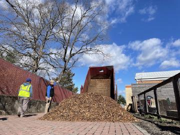 A dump truck dumping donated woodchips