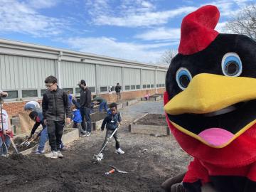 Children helping clean up the garden at Winter Wonderland with the Abingdon Cardinal looking at the camera