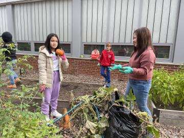 Volunteer holding a pumpkin in the Abingdon Garden